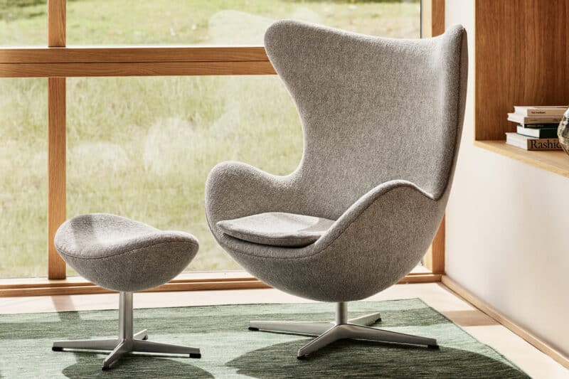 Fritz Hansen Egg Chair und Fußhocker in grauem Stoff
